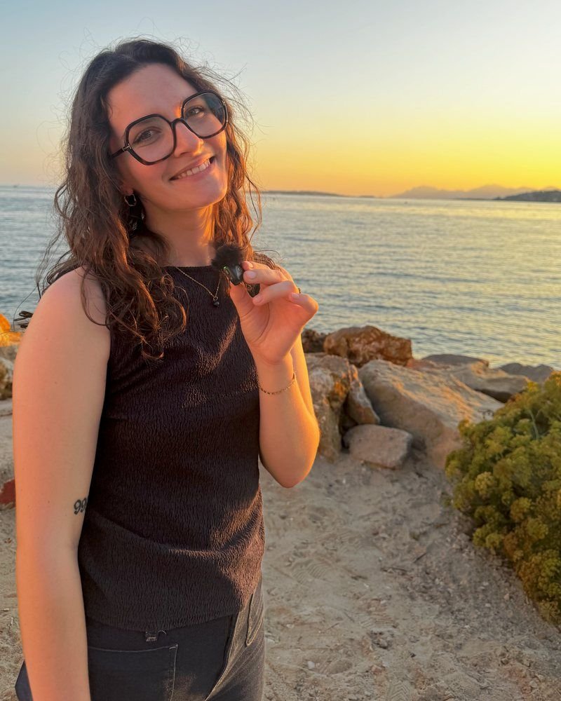 Léa Audouin, micro à la main, au bord de la mer